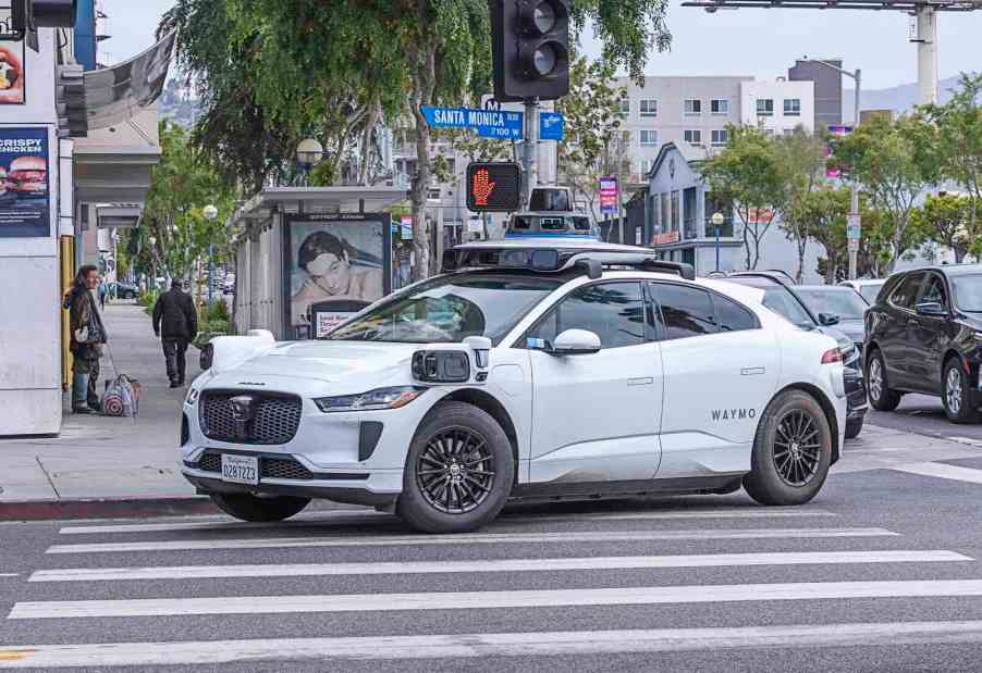 White Waymo taxi in a crosswalk in Los Angeles.