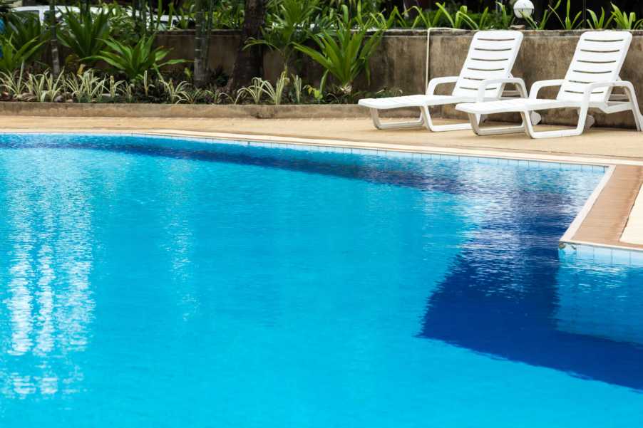 Blu water pool with two white loungers