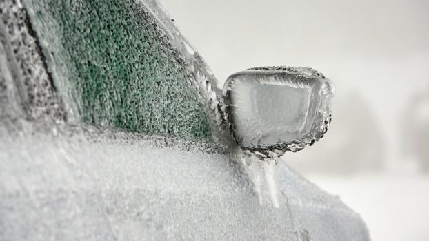 A car covered in ice in close view of right front