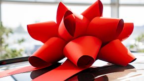 A car in a dealership showroom with red now on its roof in very close view