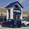 A CarMax storefront with cars parked outside