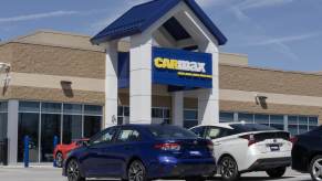 A CarMax storefront with cars parked outside