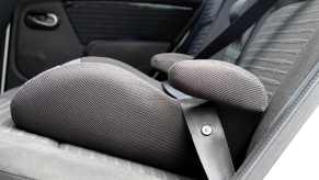 Child booster seat installed in car in close low profile view