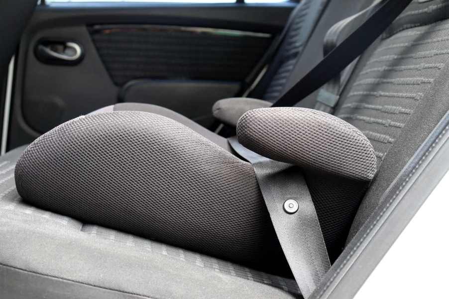 Child booster seat installed in car in close low profile view