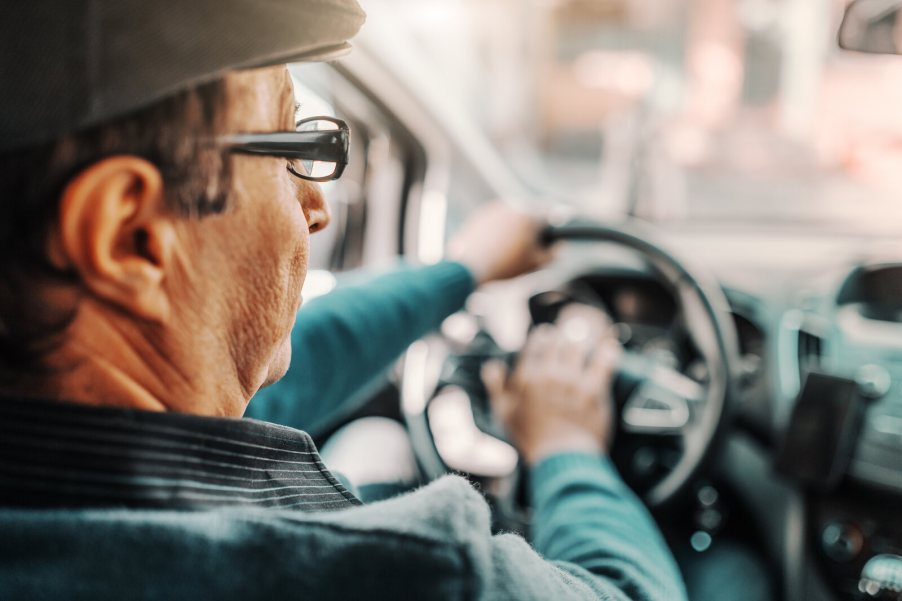 An elderly driver, view from backseat