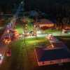 Emergency vehicles with lights on parked in front of a home from aerial view