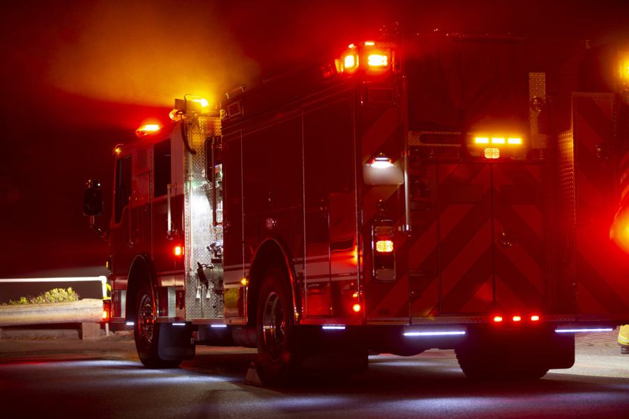 A fire truck parked across lanes at night