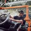 Ford factory worker with hands on an F-150 Lightning steering column