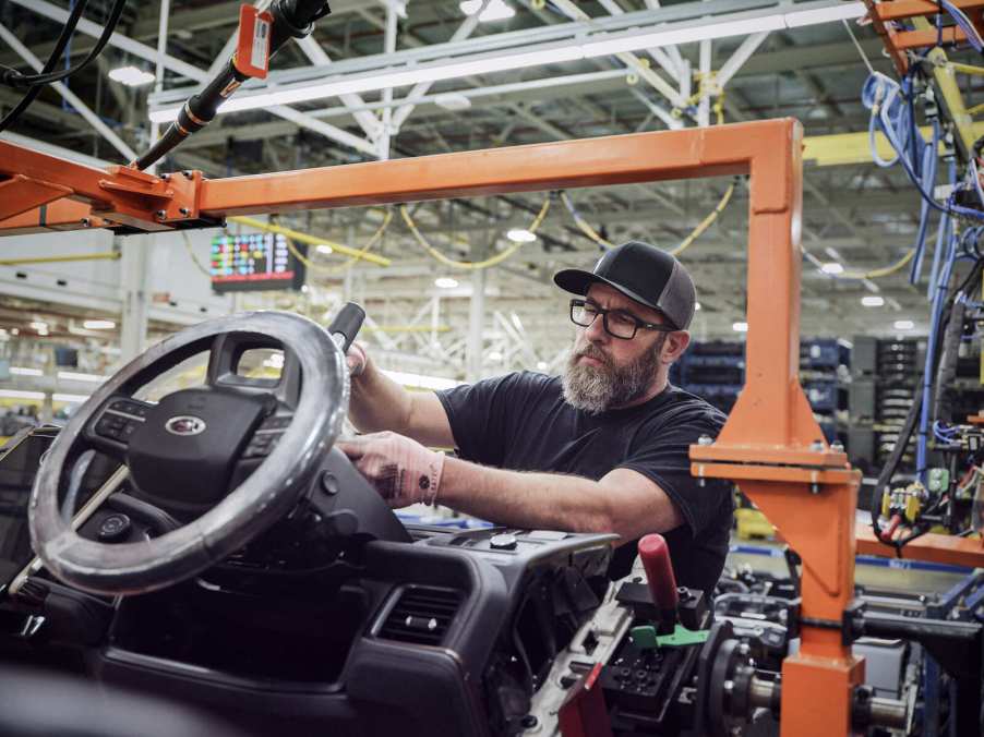 Ford factory worker with hands on an F-150 Lightning steering column