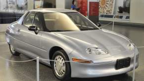 A silver GM EV1 electric car, produced from 1996-1999, parked in a museum in right front angle view