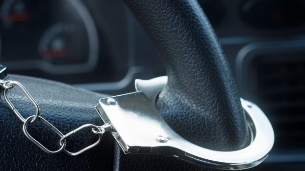 A handcuff on a car steering wheel in close view