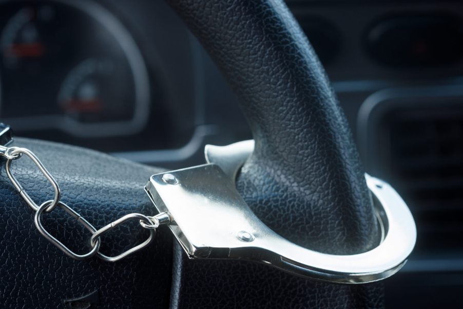 A handcuff on a car steering wheel in close view