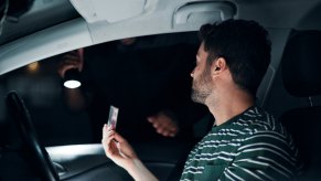 A driver hands a police officer their license at night