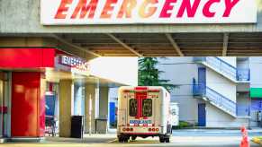 A hospital's emergency department entrance with ambulance parked outside
