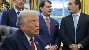 President Trump talks about kei cars as Sean Duffy, Jim Farley, and Antonio Filosa look on behind the White House desk
