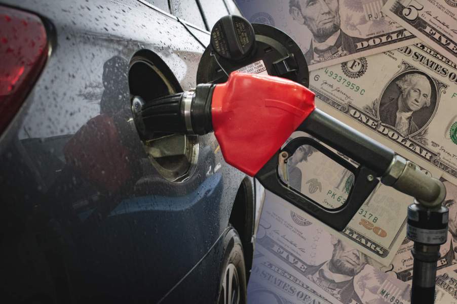 Red gas pump in a car with American money spread out in background