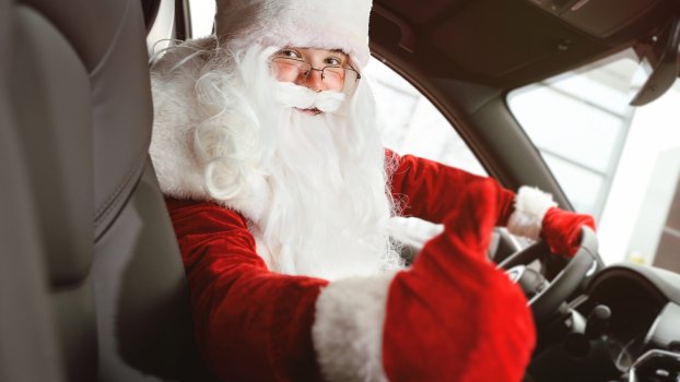 Santa driving a car giving viewer thumbs up