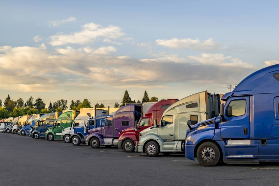 A colorful array of semi-trucks lined up diagonally view of cabs