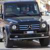 A woman driving a black Mercedes-Benz G-Wagon