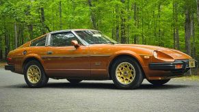A copper-colored 1981 Datsun 280ZX Turbo parked in the woods n low right profile angle view