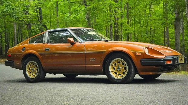 A copper-colored 1981 Datsun 280ZX Turbo parked in the woods n low right profile angle view