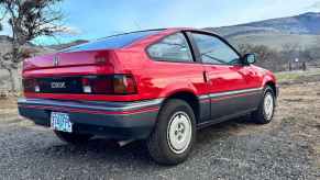 Kammtail rear of a red Honda CRX compact car, with mountains visible in the background.