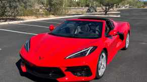 Bright red Corvette in a parking lot, the desert and cactuses visible in the background.