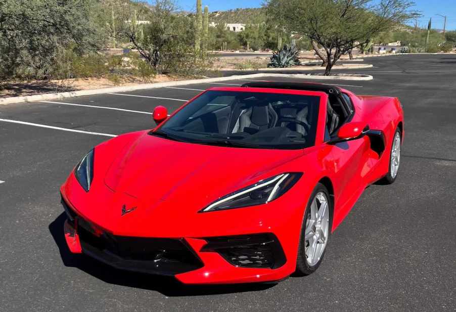 Bright red Corvette in a parking lot, the desert and cactuses visible in the background.