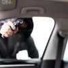 A carjacker holding a gun