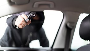 A carjacker holding a gun