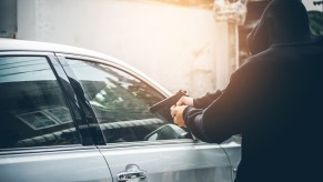 An armed man stealing a car