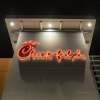 Red neon Chick-fil-A restaurant sign at night.