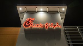Red neon Chick-fil-A restaurant sign at night.