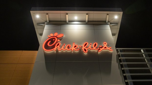 Red neon Chick-fil-A restaurant sign at night.