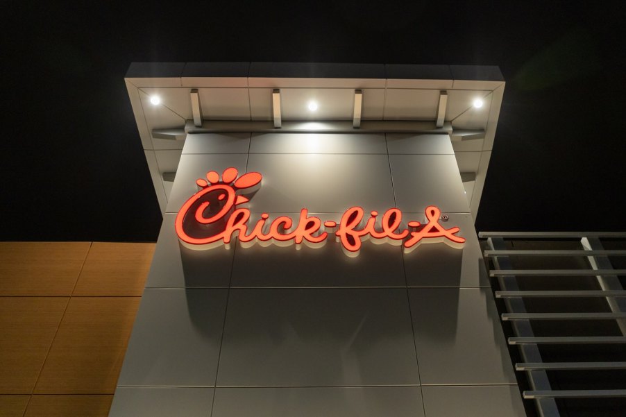 Red neon Chick-fil-A restaurant sign at night.