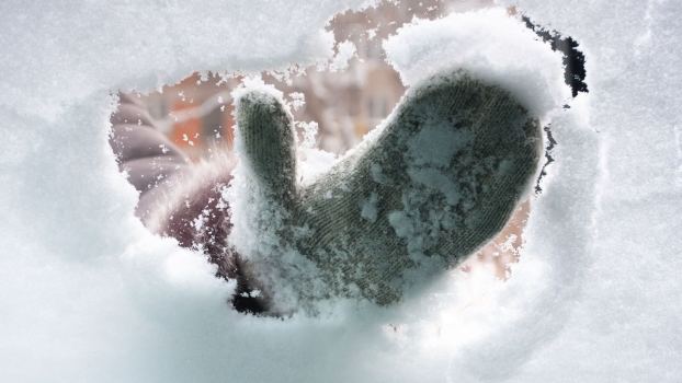 Driver wearing mittens brushes snow off Chinese car in Russian winter