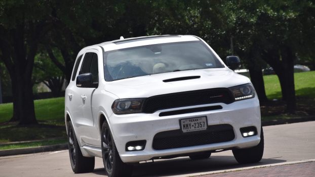 White Dodge Durango SUV parked in front of a row of SUVs.