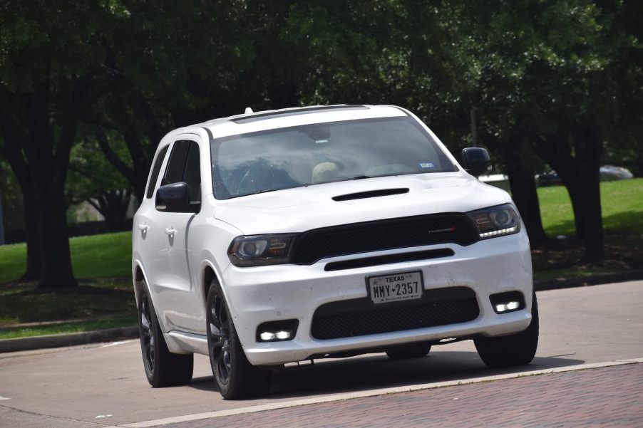 White Dodge Durango SUV parked in front of a row of SUVs.
