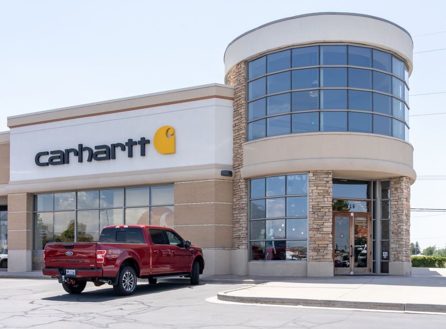 Red Ford F-150 pickup truck parked outside Carhartt store