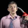 Upset man holds fuel pump nozzle to his head