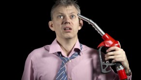 Upset man holds fuel pump nozzle to his head