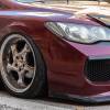 Red Honda Civic on aftermarket wheels parked on the street.