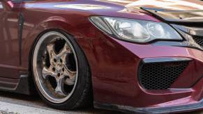 Red Honda Civic on aftermarket wheels parked on the street.