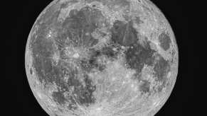 Closeup of the moon above earth through a telescope.