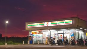 Row of motorcycles parked in front of 7-Eleven gas station and convenience store.