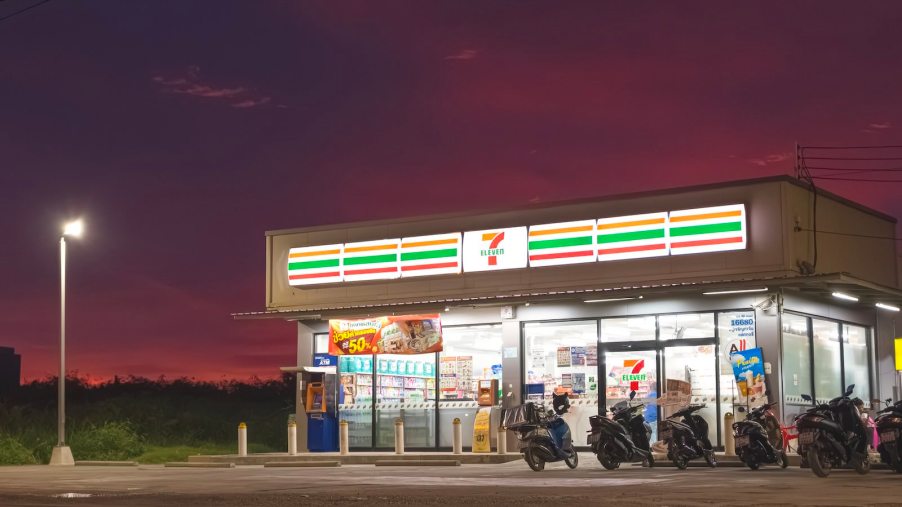 Row of motorcycles parked in front of 7-Eleven gas station and convenience store.
