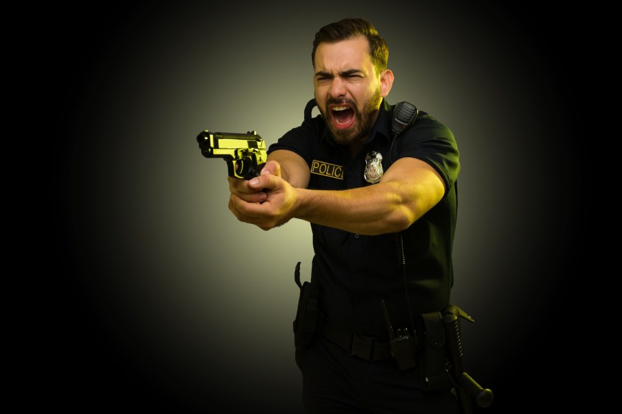 Police officer holding a gun and yelling after car thief backed over his foot.