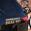 "Emergency Dial 911" sticker on the side of a black police patrol car