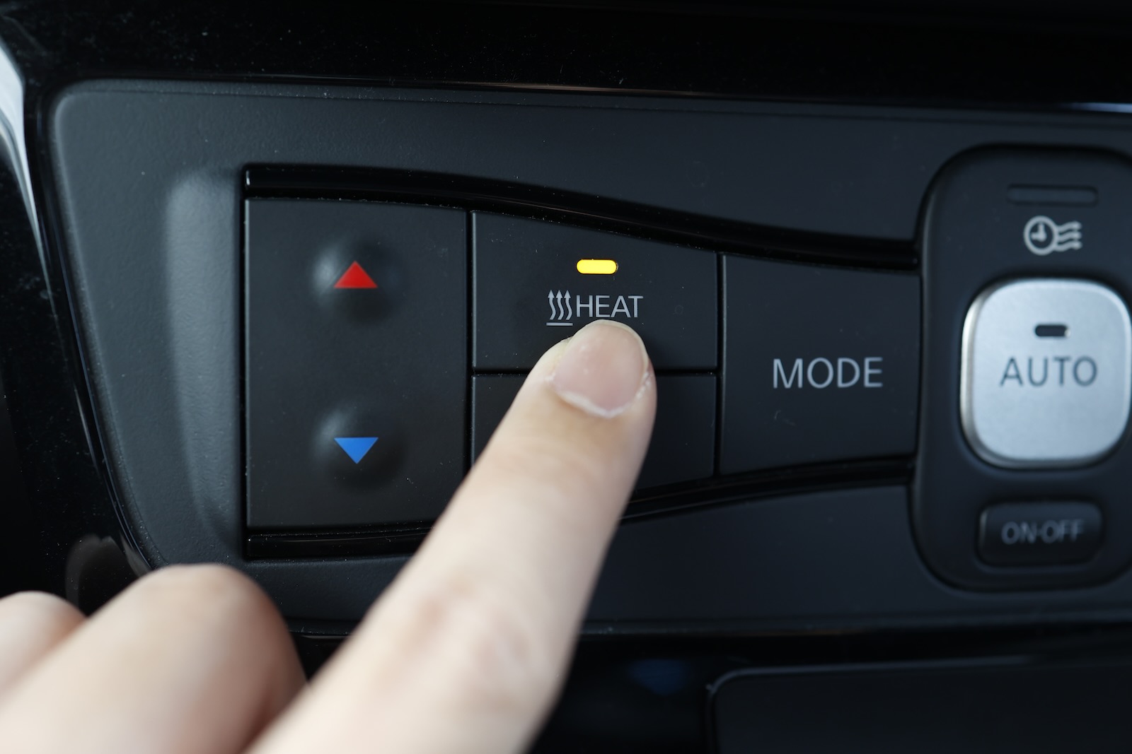 Physical heat button in the interior of a Kia car.