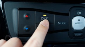 Physical heat button in the interior of a Kia car.